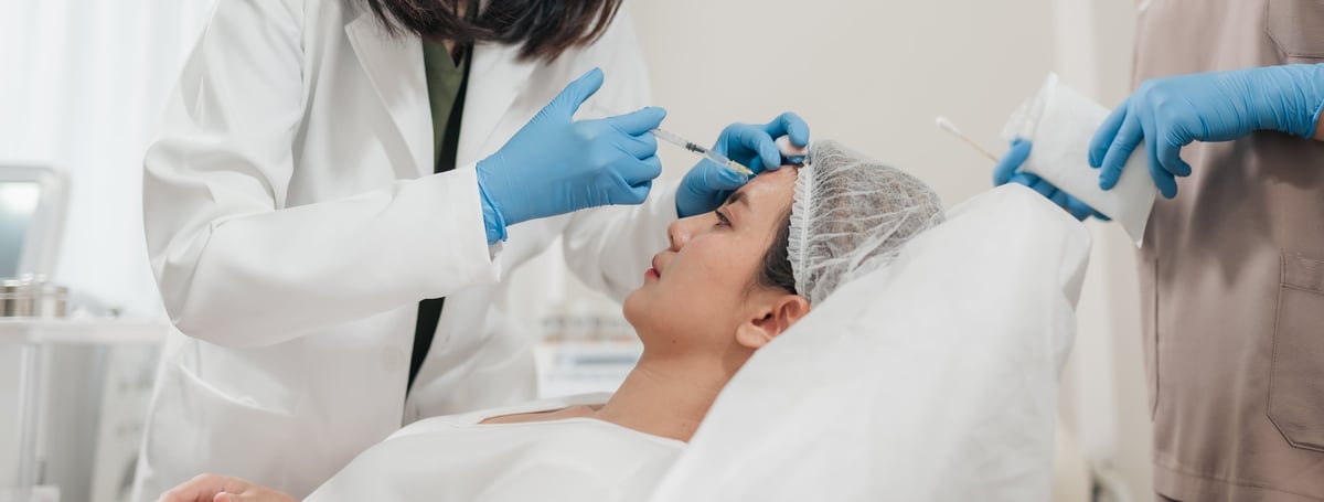 Mujer recibiendo inyección de botox antiarrugas en clínica estética