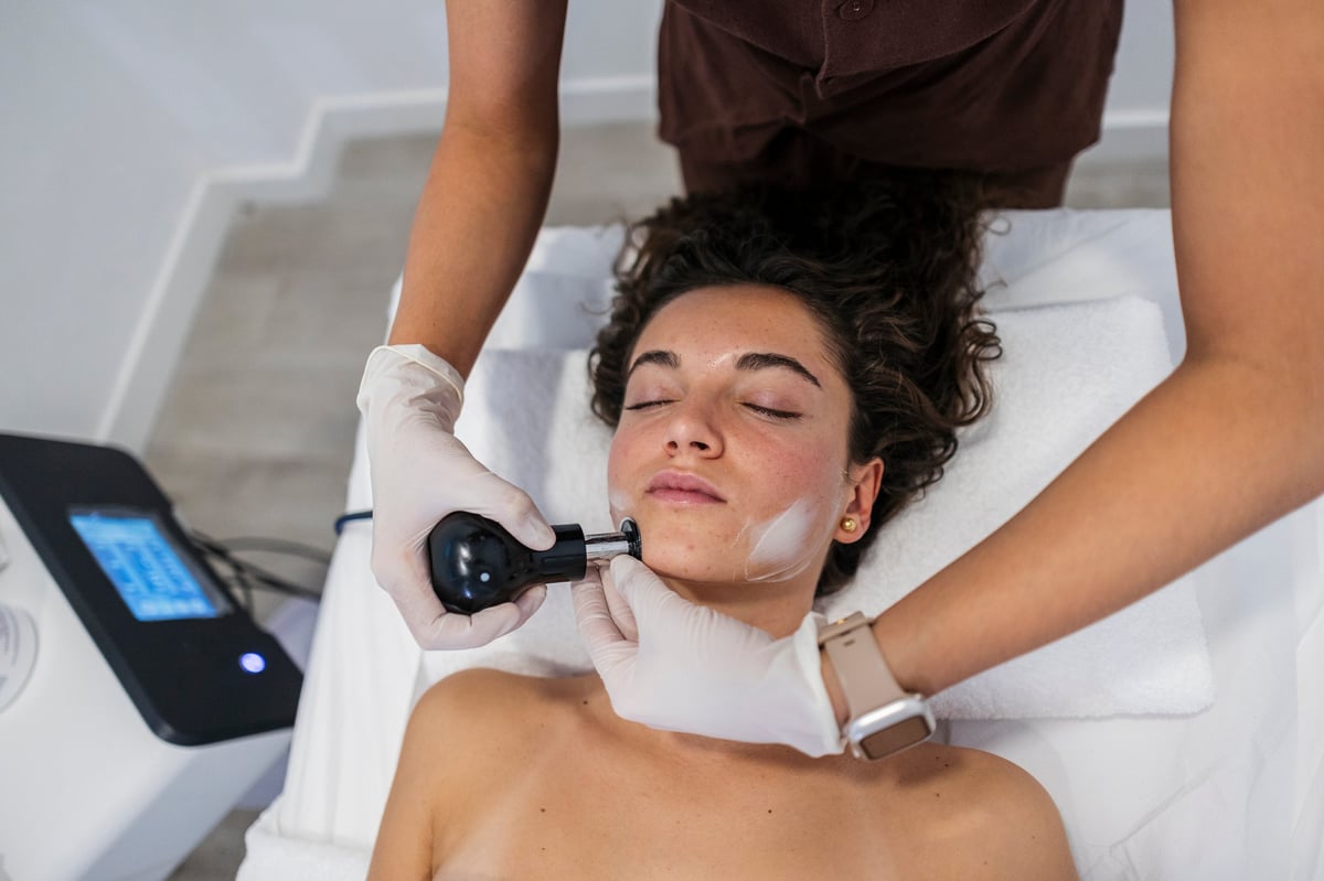 Mujer recibiendo tratamiento de radiofrecuencia facial para rejuvenecimiento de la piel en clínica estética