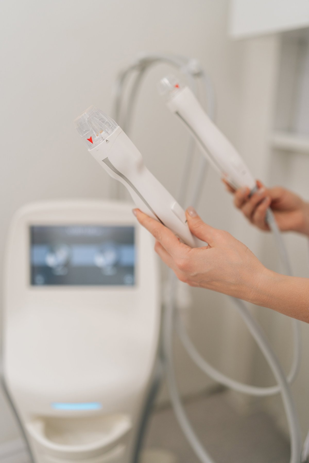 Closeup of beautician holding handles of fractional radiofrequency device for facial lifting and skin tightening treatment